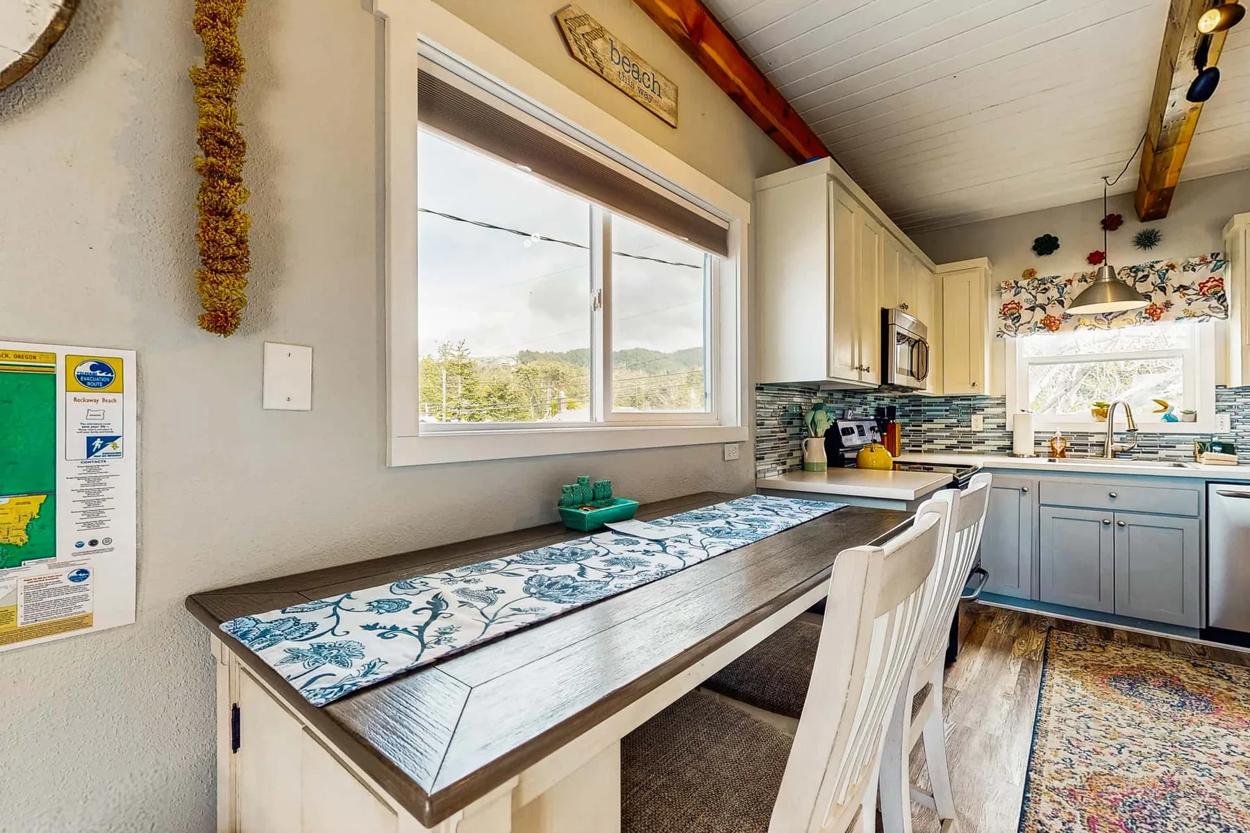 A bright kitchen dining nook with a long counter, chairs, and a window.