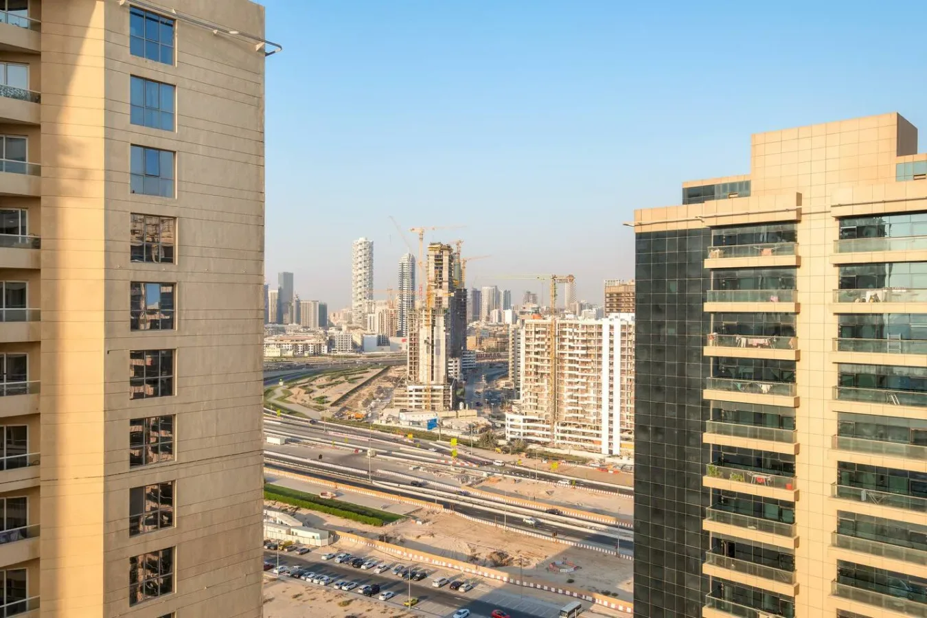 City skyline viewed between tall buildings, with elevated roads crossing the foreground.