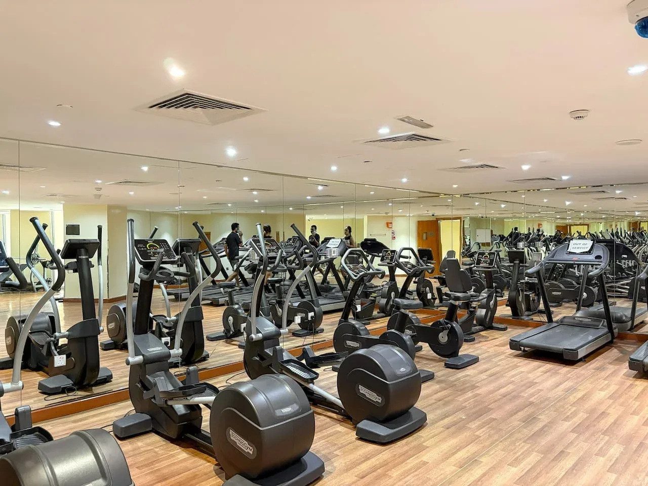A spacious gym with exercise machines and mirrored walls.