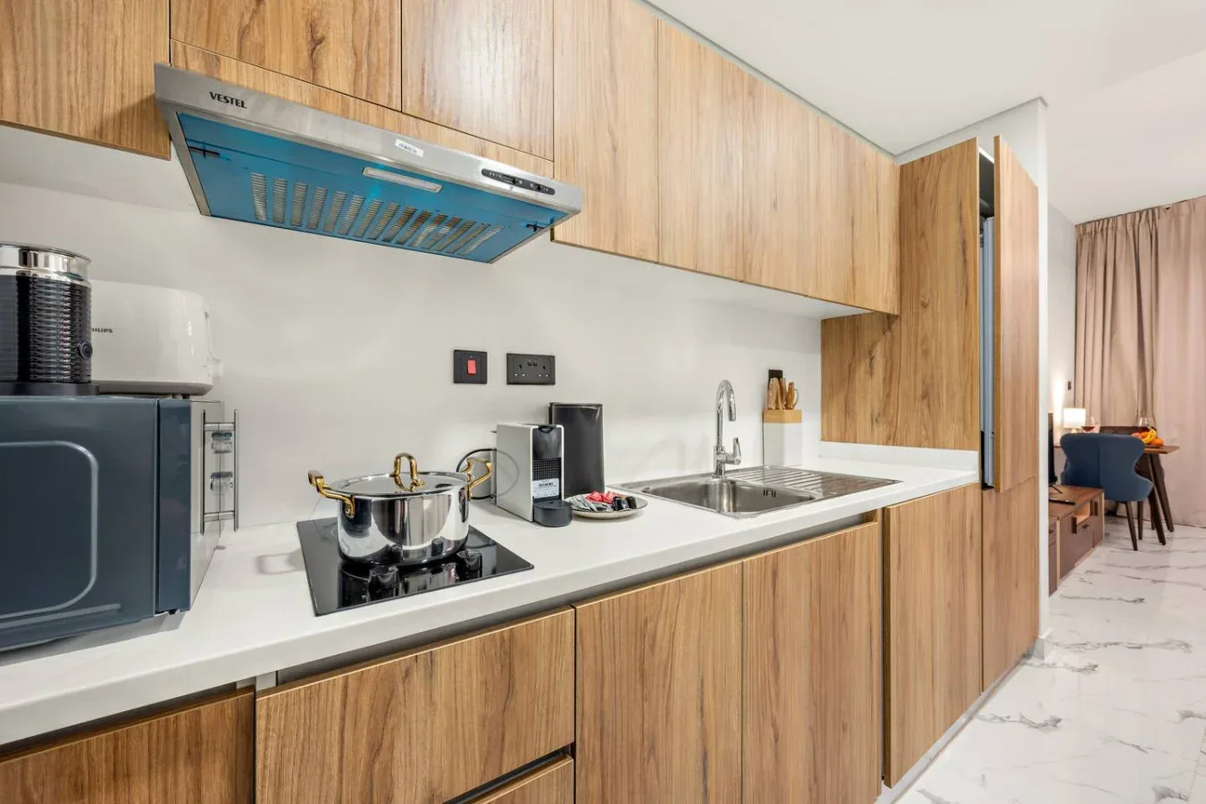 Una cocina moderna con gabinetes de madera, una encimera y un fregadero.