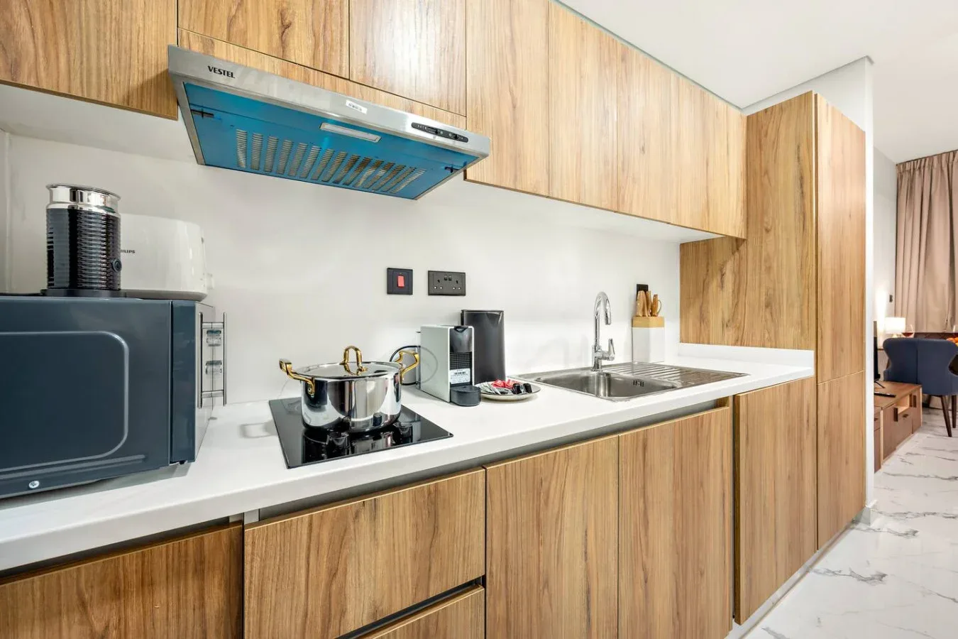 Una cocina moderna con gabinetes de madera, encimera y electrodomésticos.