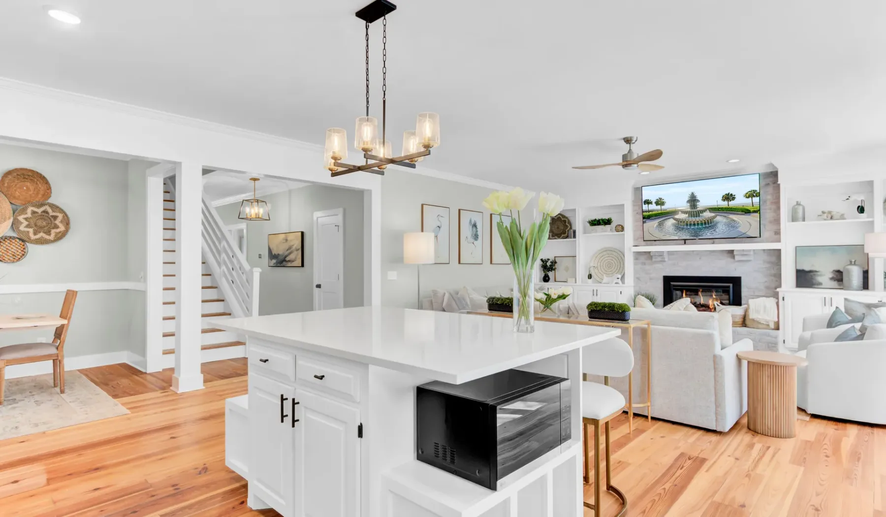 Open-plan living area with a white kitchen island and seating.