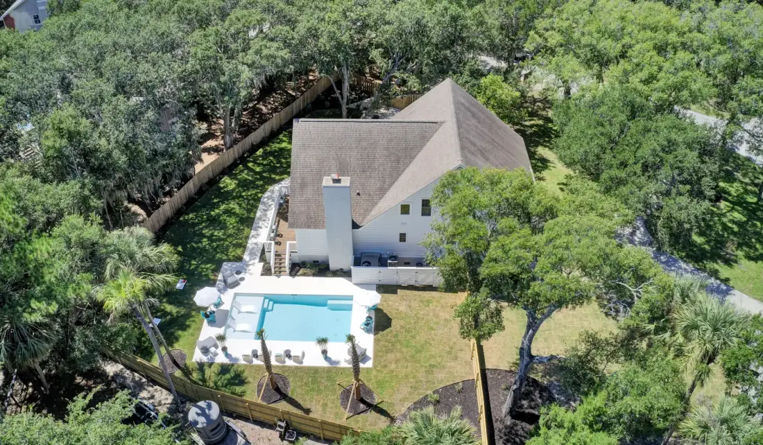 An aerial view shows a house, swimming pool, and surrounding trees.