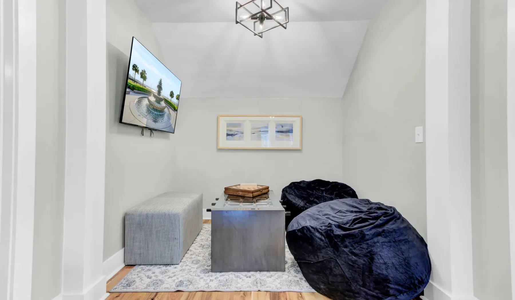 A small lounge area with floor seating, a low table, and a wall-mounted television.