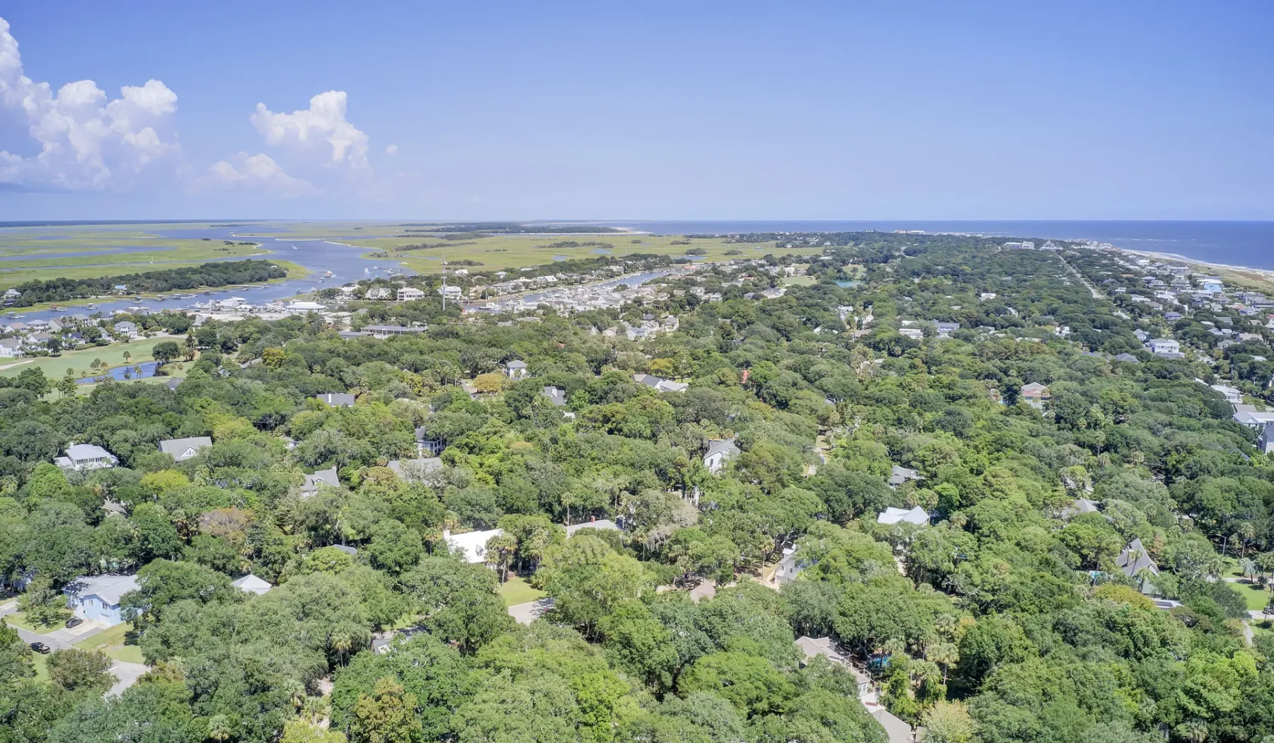 Aerial view of a coastal settlement surrounded by dense green vegetation.