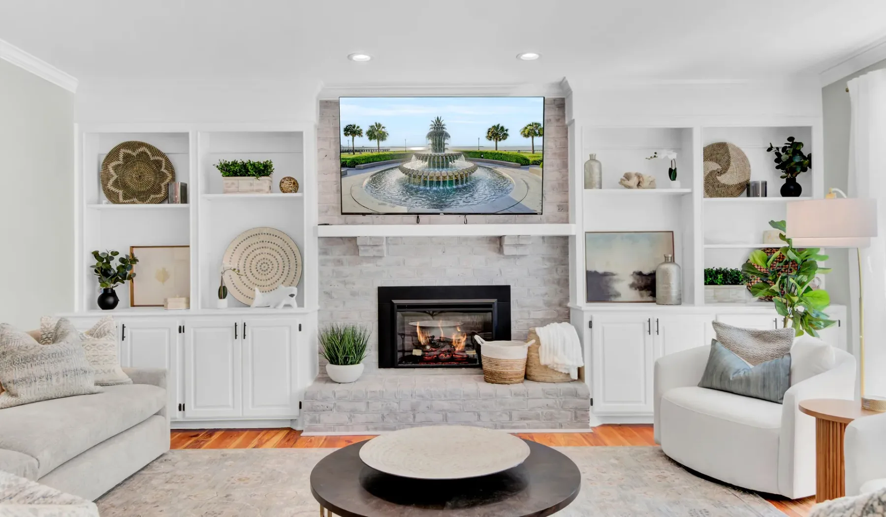 A bright living room with built-in shelving and a fireplace.
