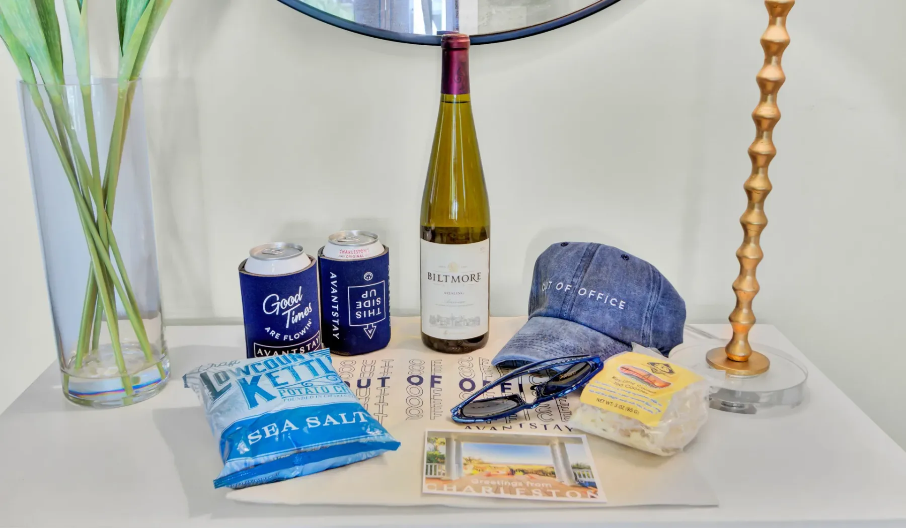 A tabletop display features drinks, a cap, packaged snacks, and printed materials.