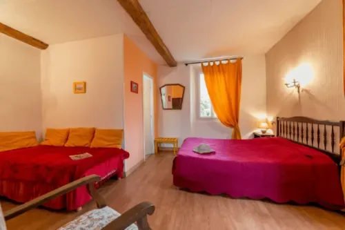 Bright guest room with colorful accents, wooden beams and mountain views.