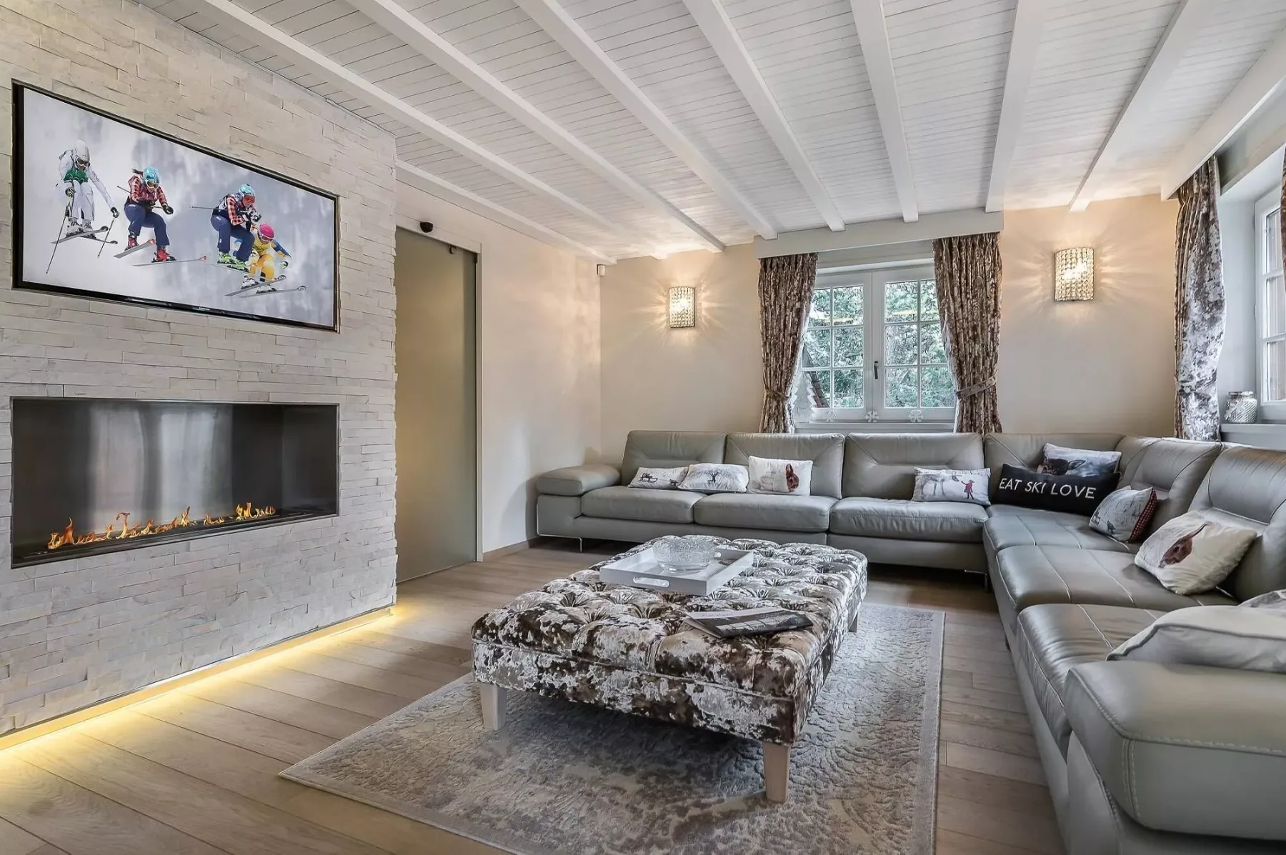 Una sala luminosa con asientos seccionales, una mesa de centro y una chimenea.