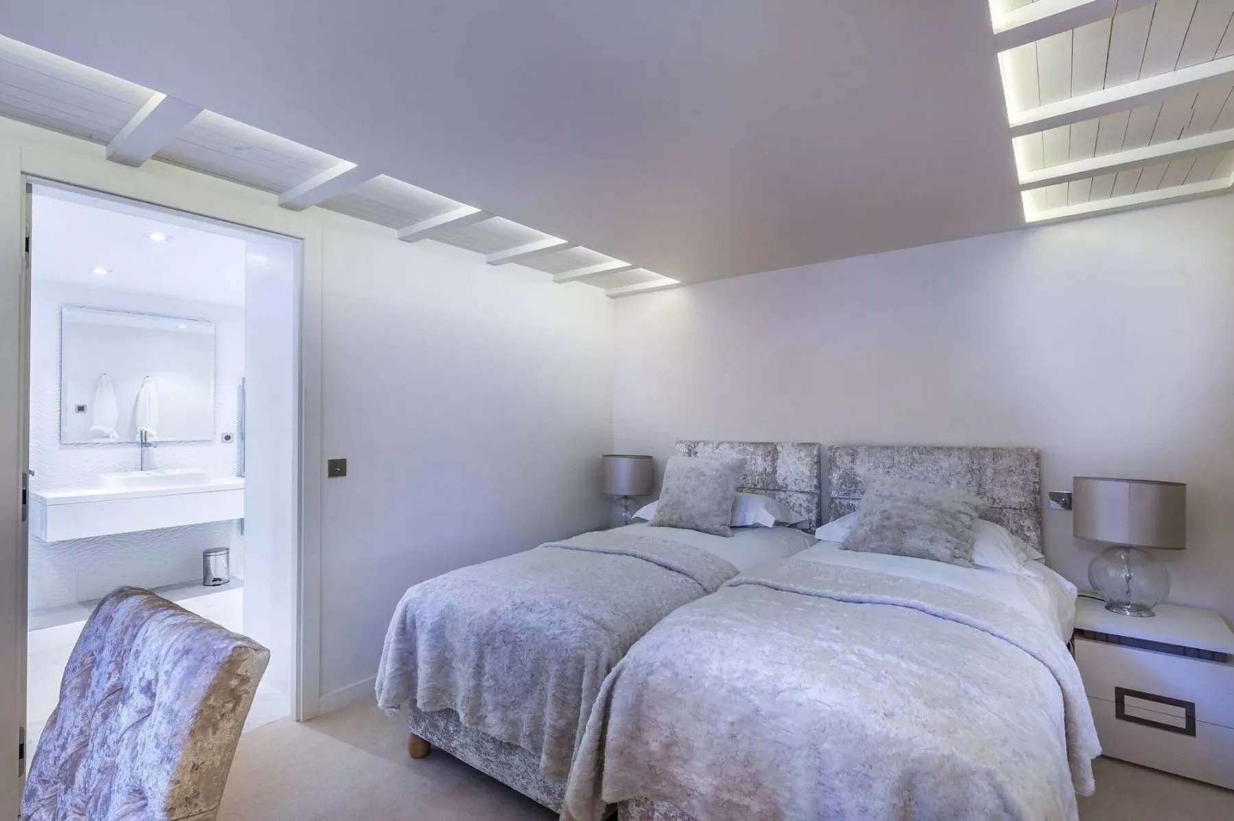 Un dormitorio con dos camas y un baño contiguo.