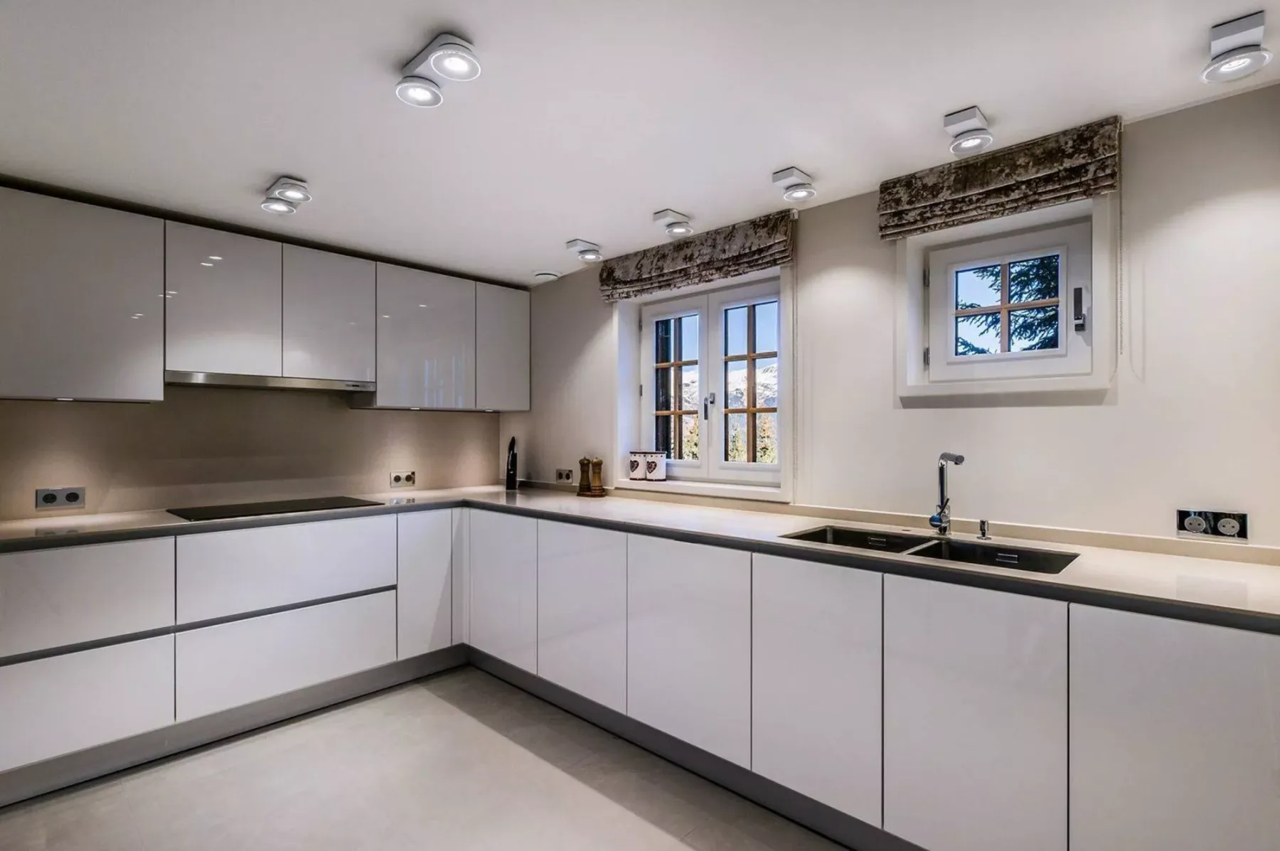 Una cocina moderna y luminosa con gabinetes blancos y una encimera oscura.