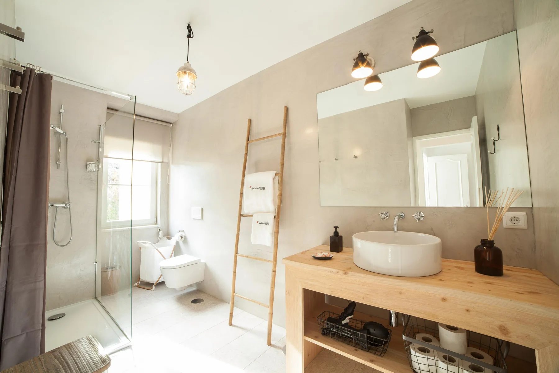 A bright bathroom with a glass shower, sink, and large mirror.