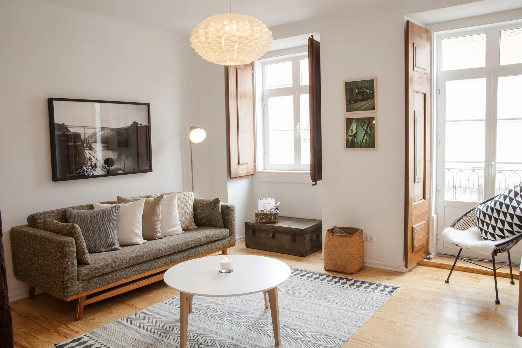 A bright living room with seating, a coffee table, and large windows.