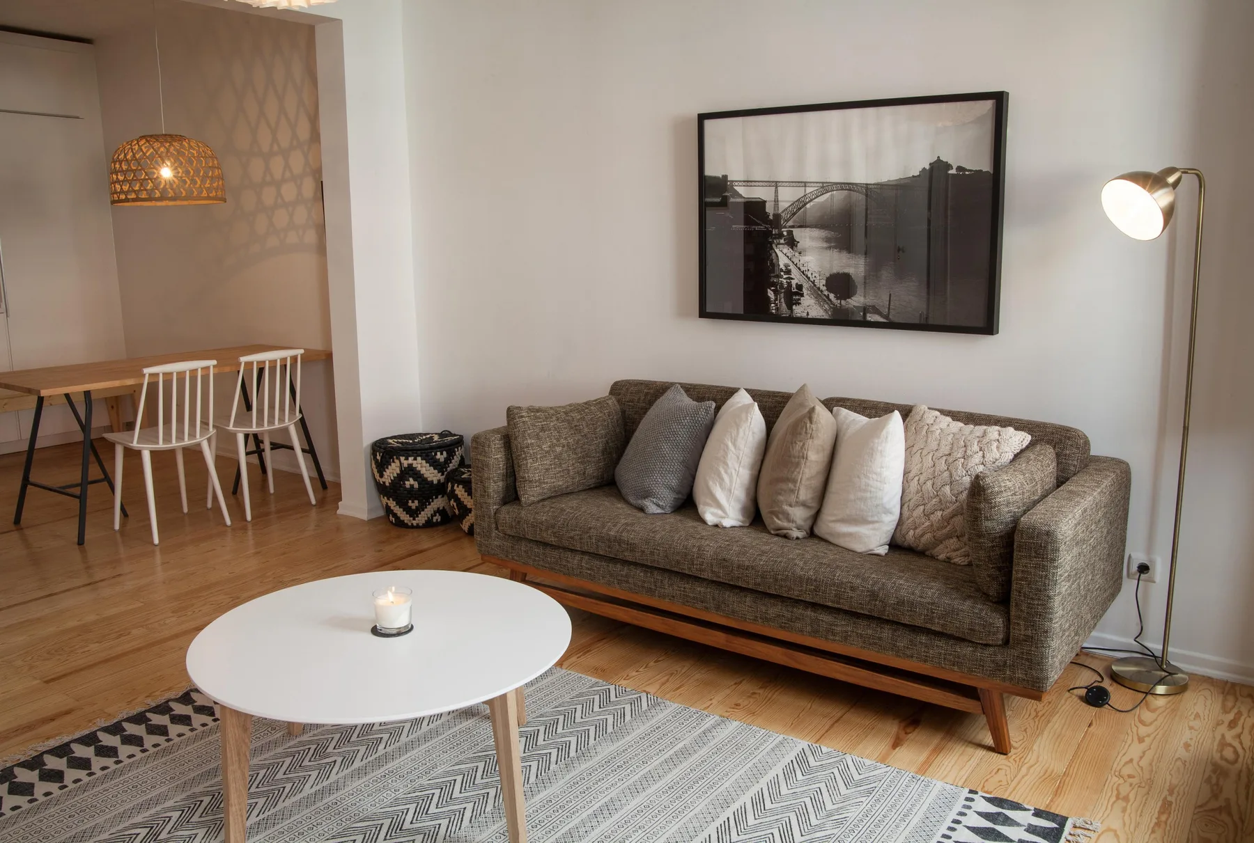 A living room with a sofa, a round coffee table, and a floor lamp.