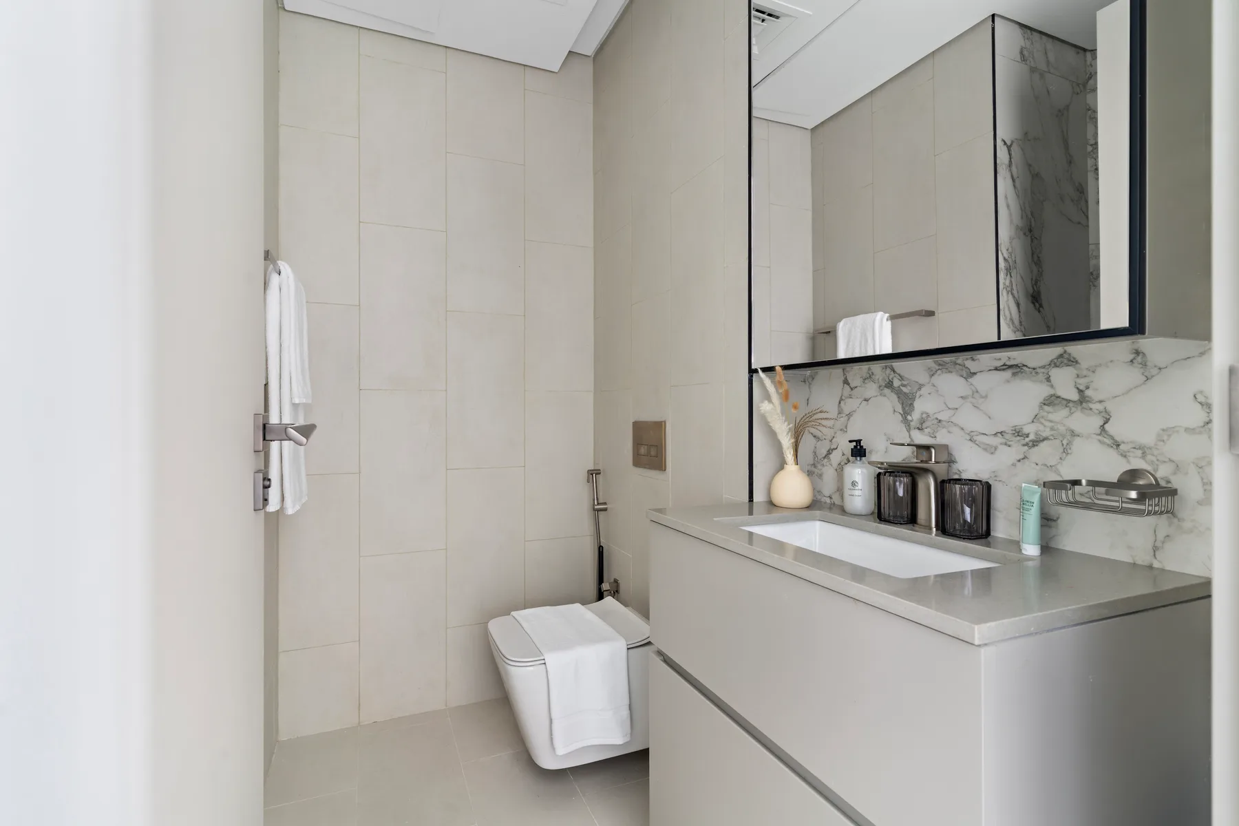 Un baño moderno con mueble de lavabo, lavamanos y un gran espejo.
