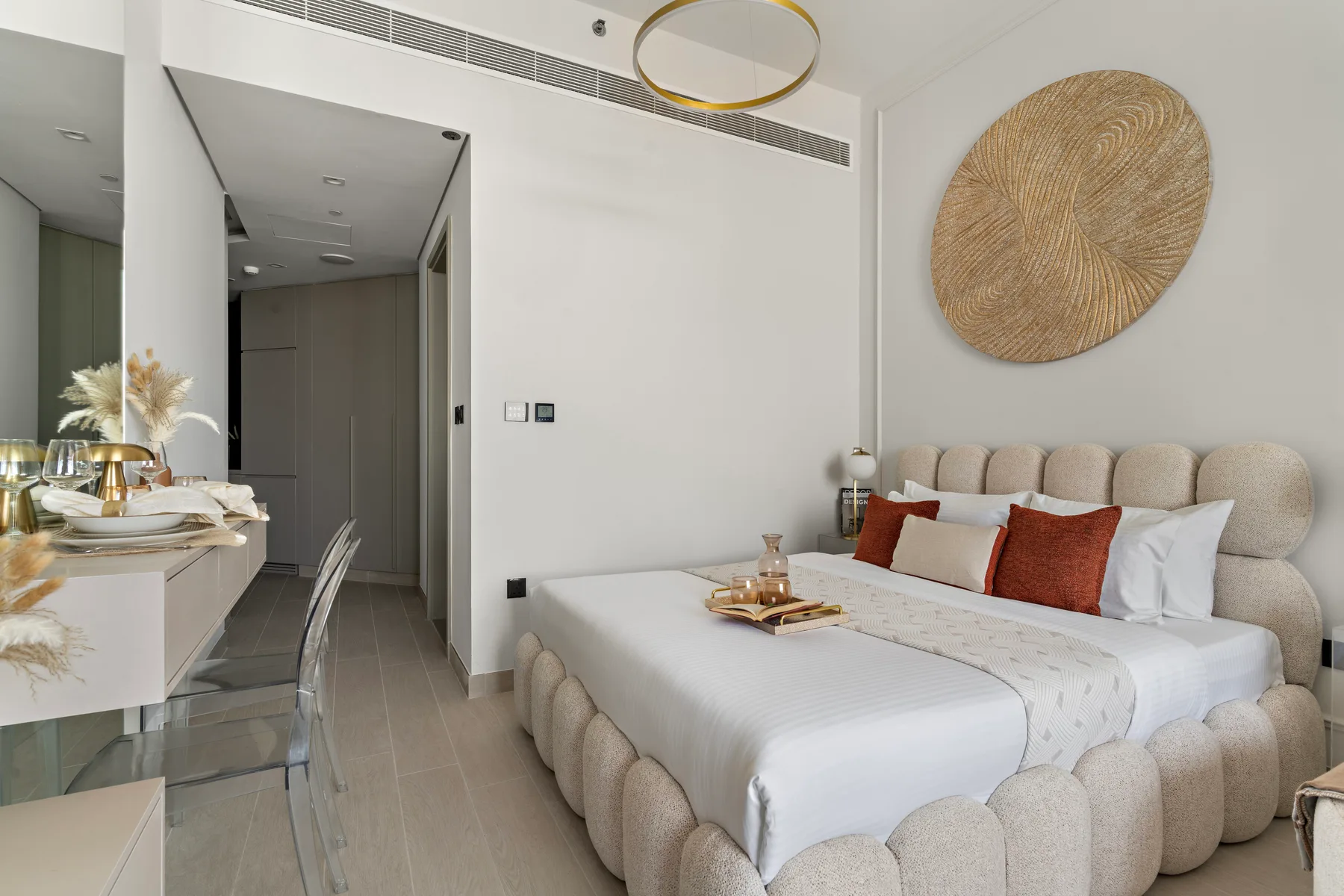 Un dormitorio luminoso con una cama grande y un comedor contiguo.
