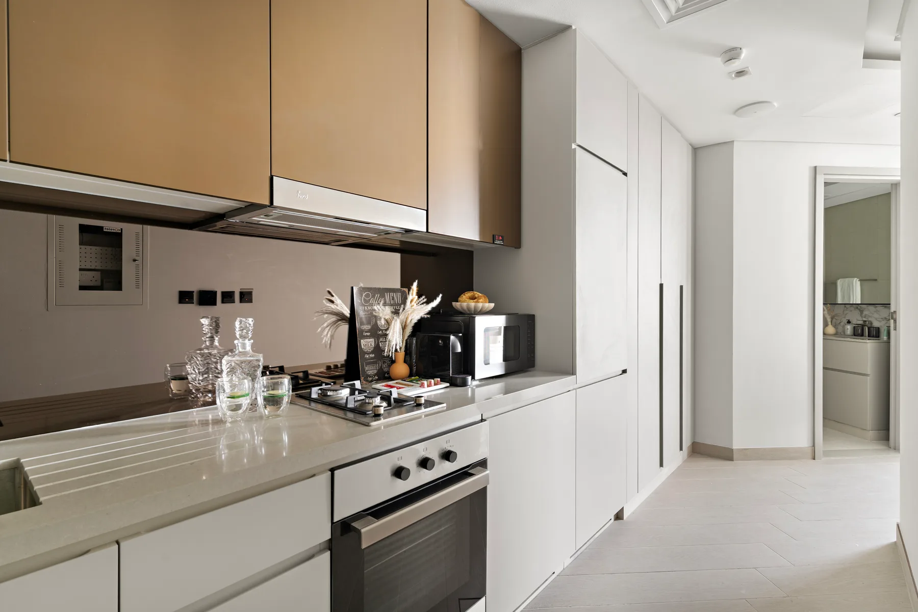 Una cocina moderna con encimeras claras, armarios y un horno integrado.