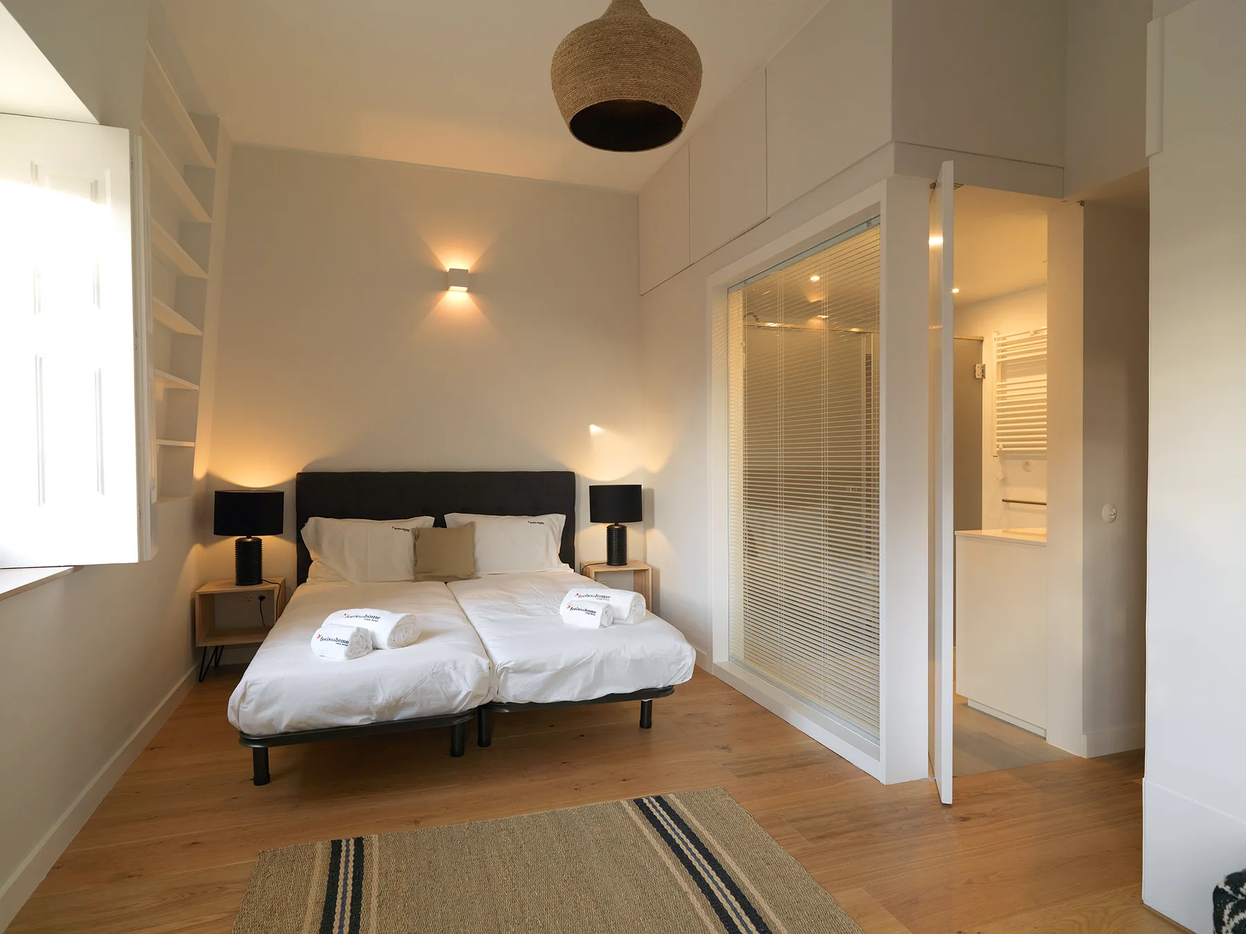 A bedroom with a double bed and a glass-paneled doorway.