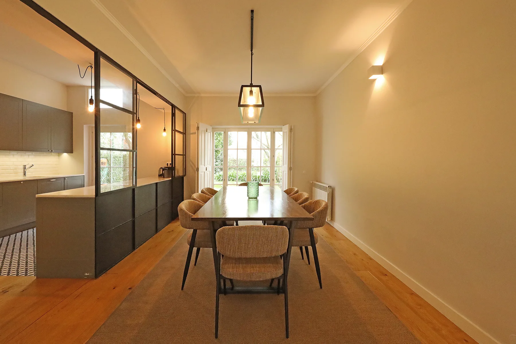 A dining area with a wooden table and chairs beside a kitchen.