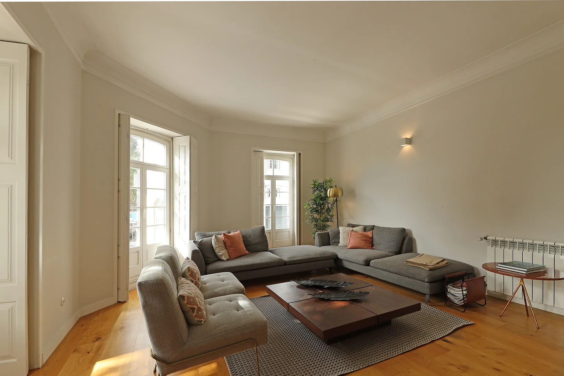 A bright living room with seating arranged around a low coffee table.