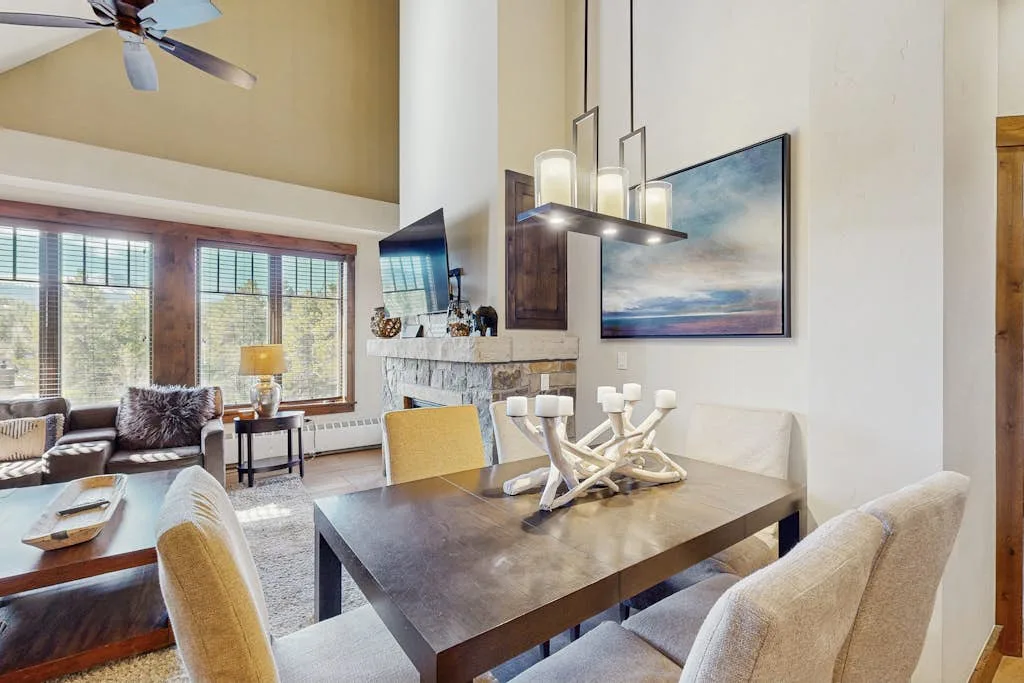 An open dining and living area with a large table beside the windows.