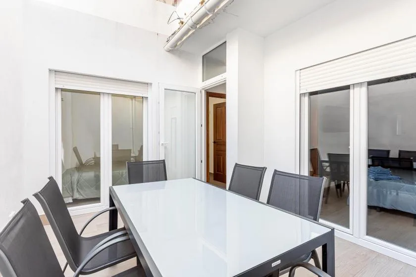 A bright dining area with a long table and sliding glass doors.