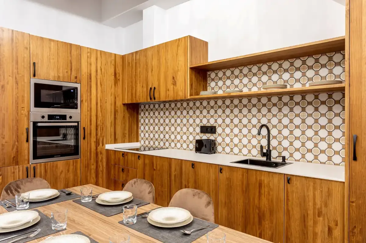 A kitchen and dining area with wooden cabinets and a table set for a meal.