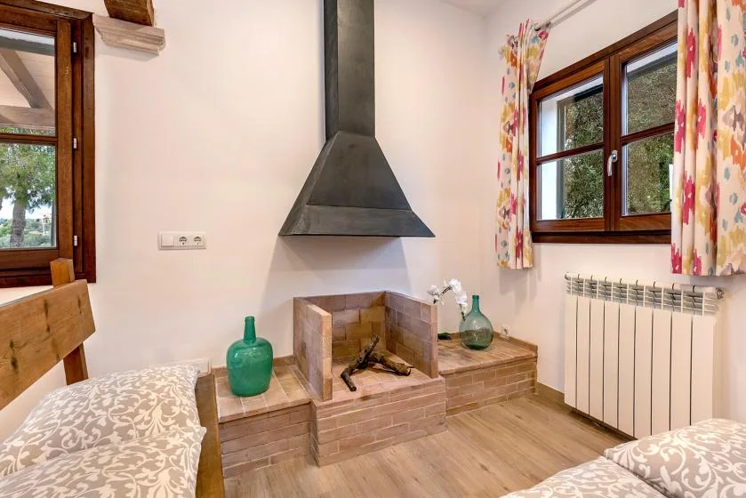 A bedroom sitting area features a brick fireplace between two windows.
