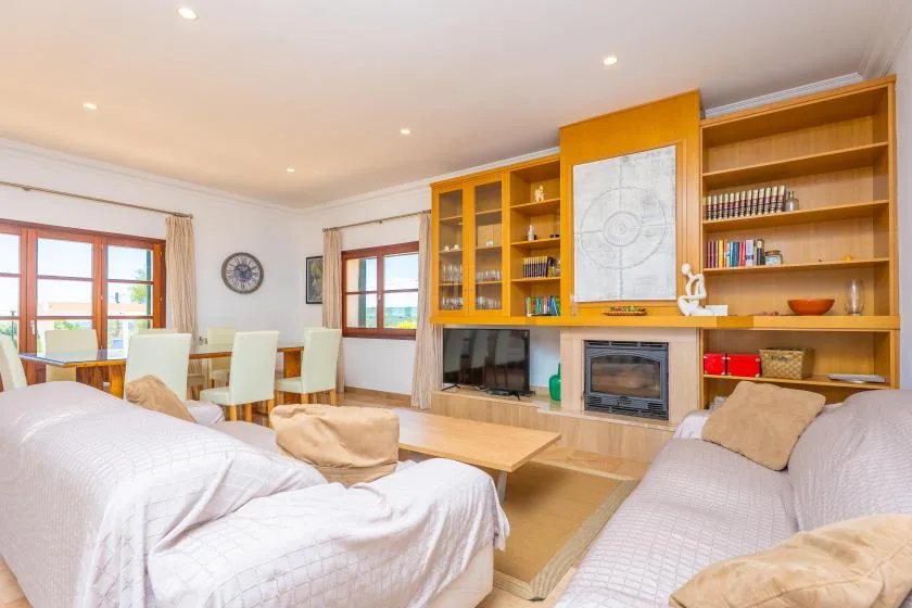 A bright living room with seating, a coffee table, and built-in shelving around a fireplace.