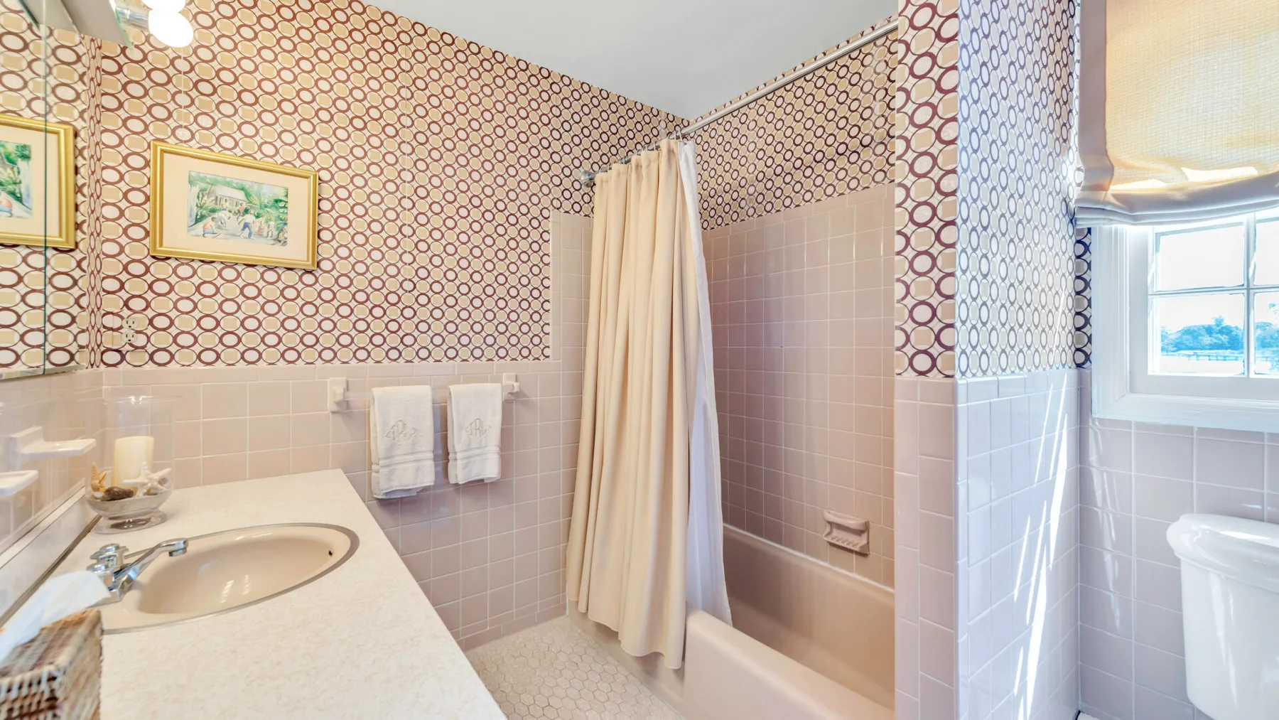 Un baño con bañera, lavabo y ventana.