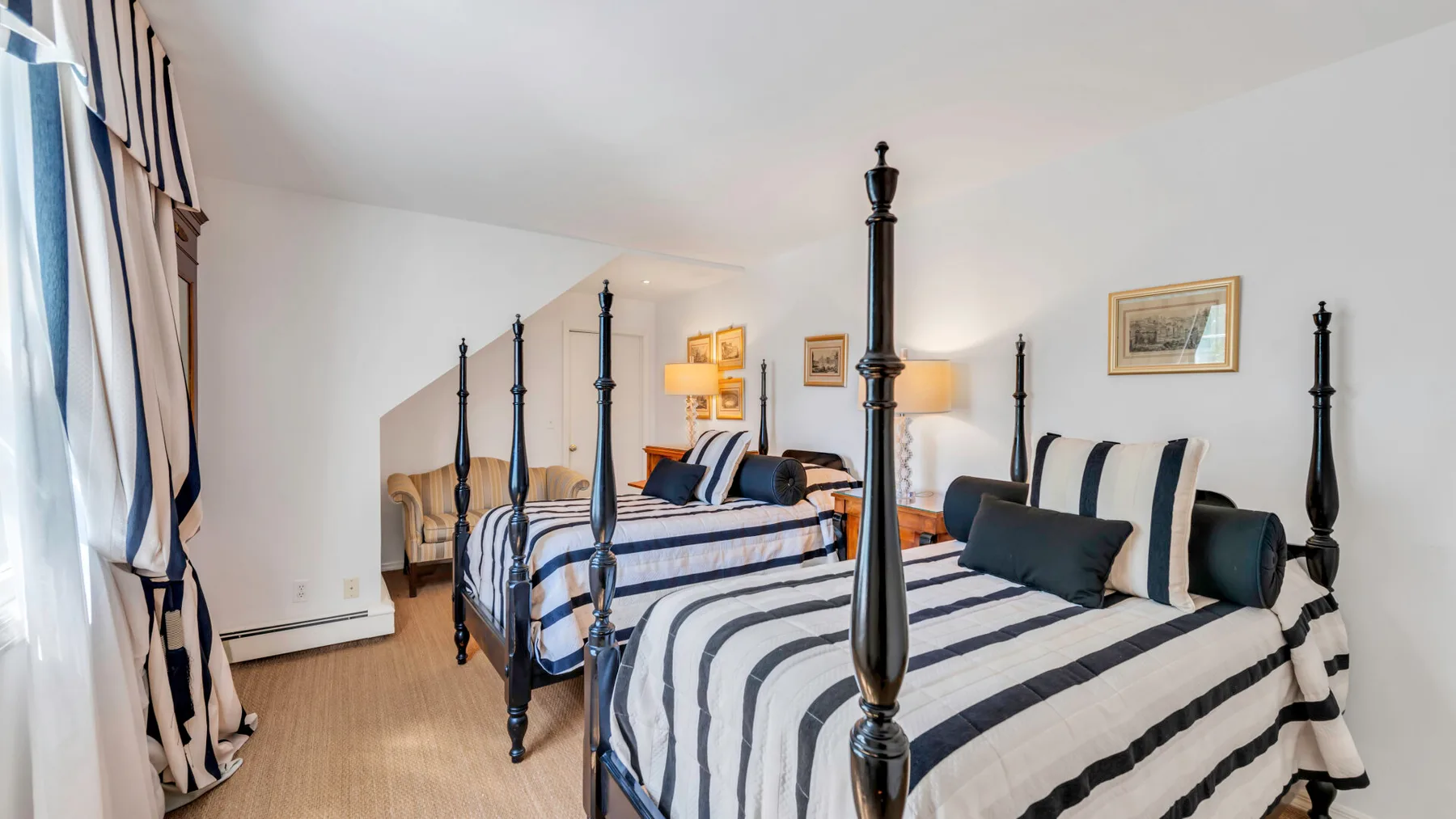 Un dormitorio con dos camas vestidas con ropa de cama a rayas.