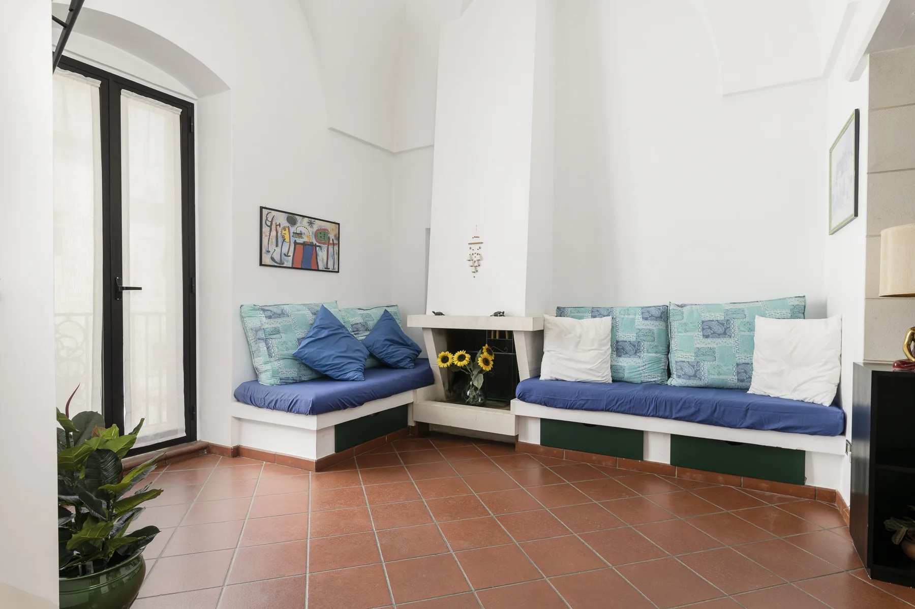 A bright sitting area with built-in bench seating and colorful cushions.