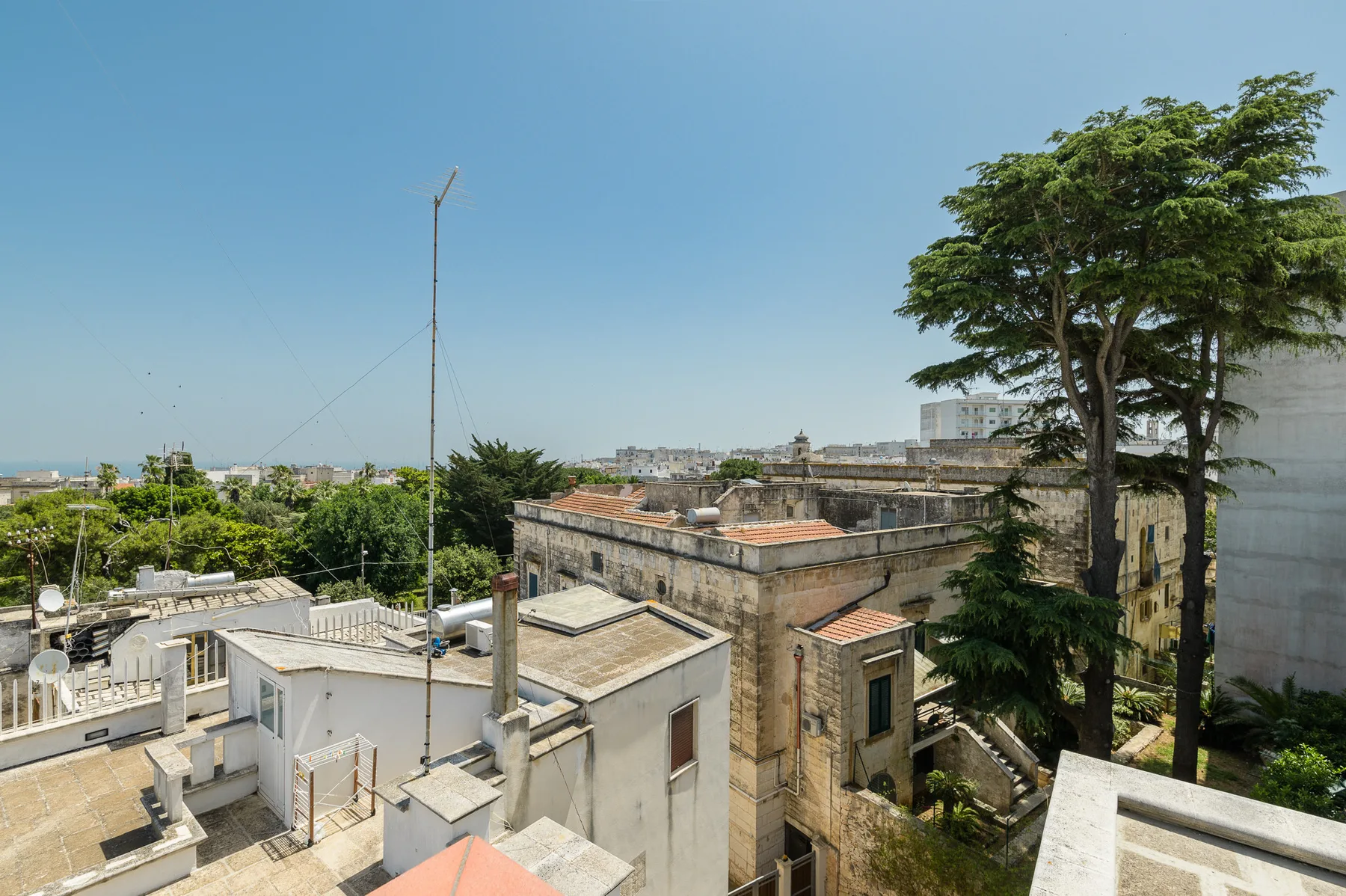 Se ven tejados y edificios cercanos bajo un cielo azul despejado.