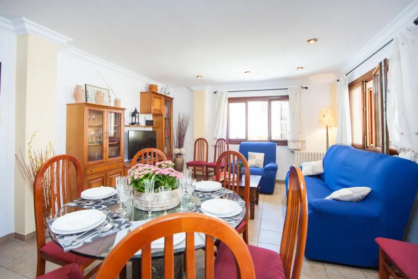 A living and dining room with blue seating and a set dining table.
