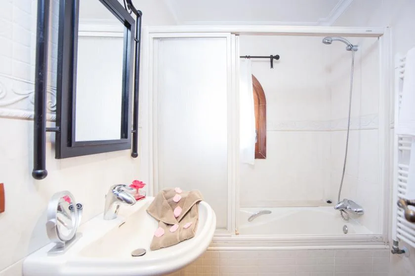 A bathroom with a sink and a glass shower enclosure.