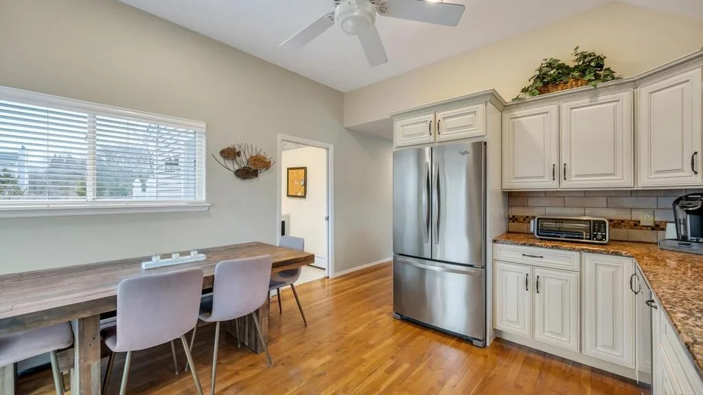 A kitchen and dining area with a wooden table beside the window.
