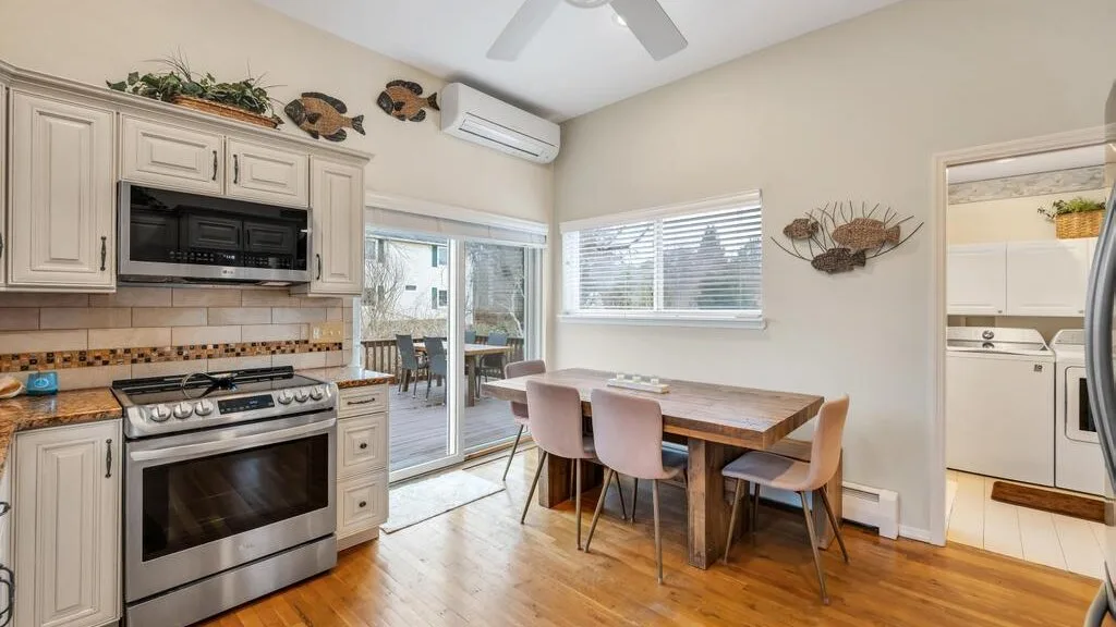 A kitchen and dining area with a wooden table beside the sliding glass doors.