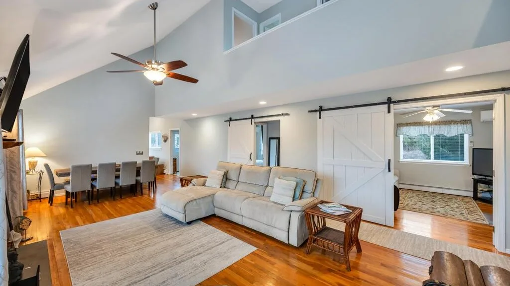 Una amplia sala de estar con una zona de asientos y una mesa de comedor.