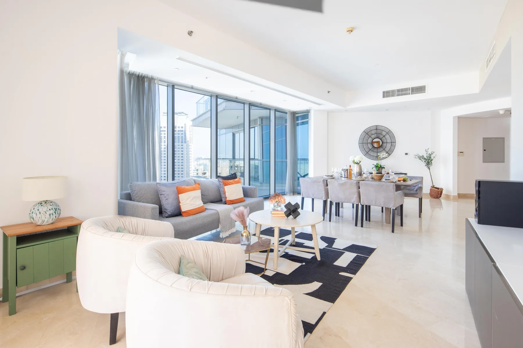 Una luminosa sala-comedor abierta con grandes ventanas y asientos.