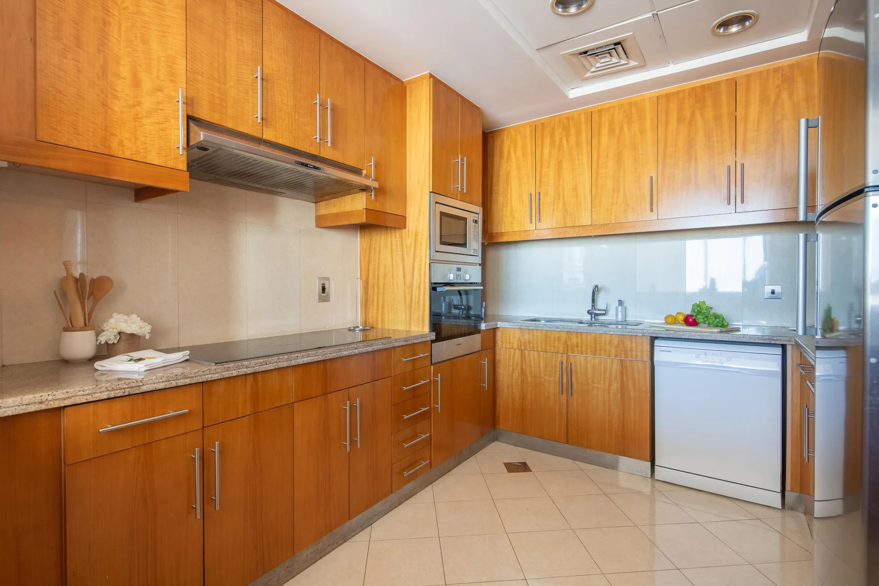 Una cocina con gabinetes de madera, una encimera y electrodomésticos integrados.