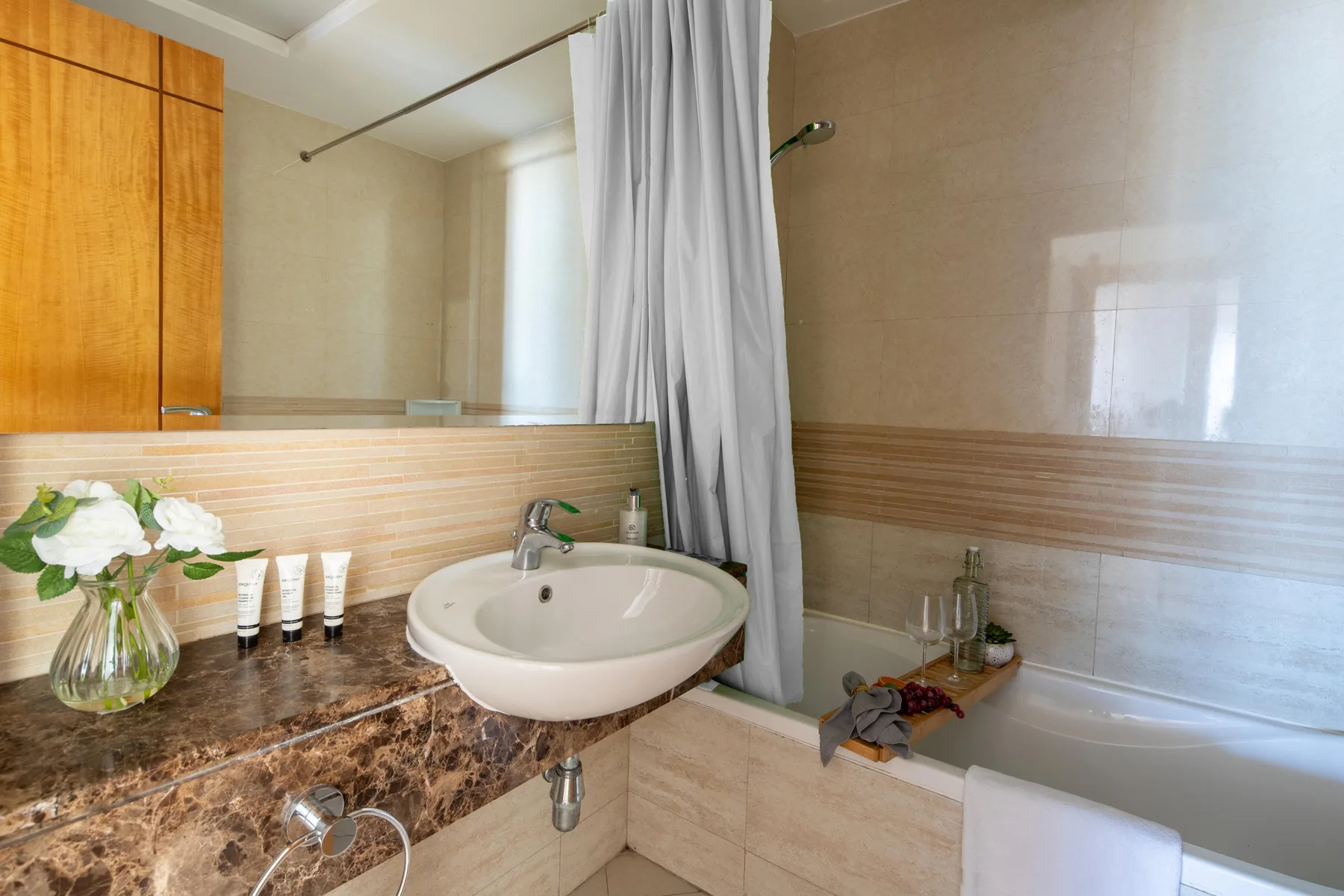 Un lavabo de baño está junto a una bañera y una cortina de ducha.