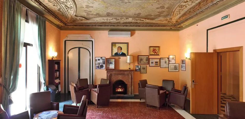 Estancia interior con paredes de color melocotón, techo con motivos decorativos, chimenea y sillones.