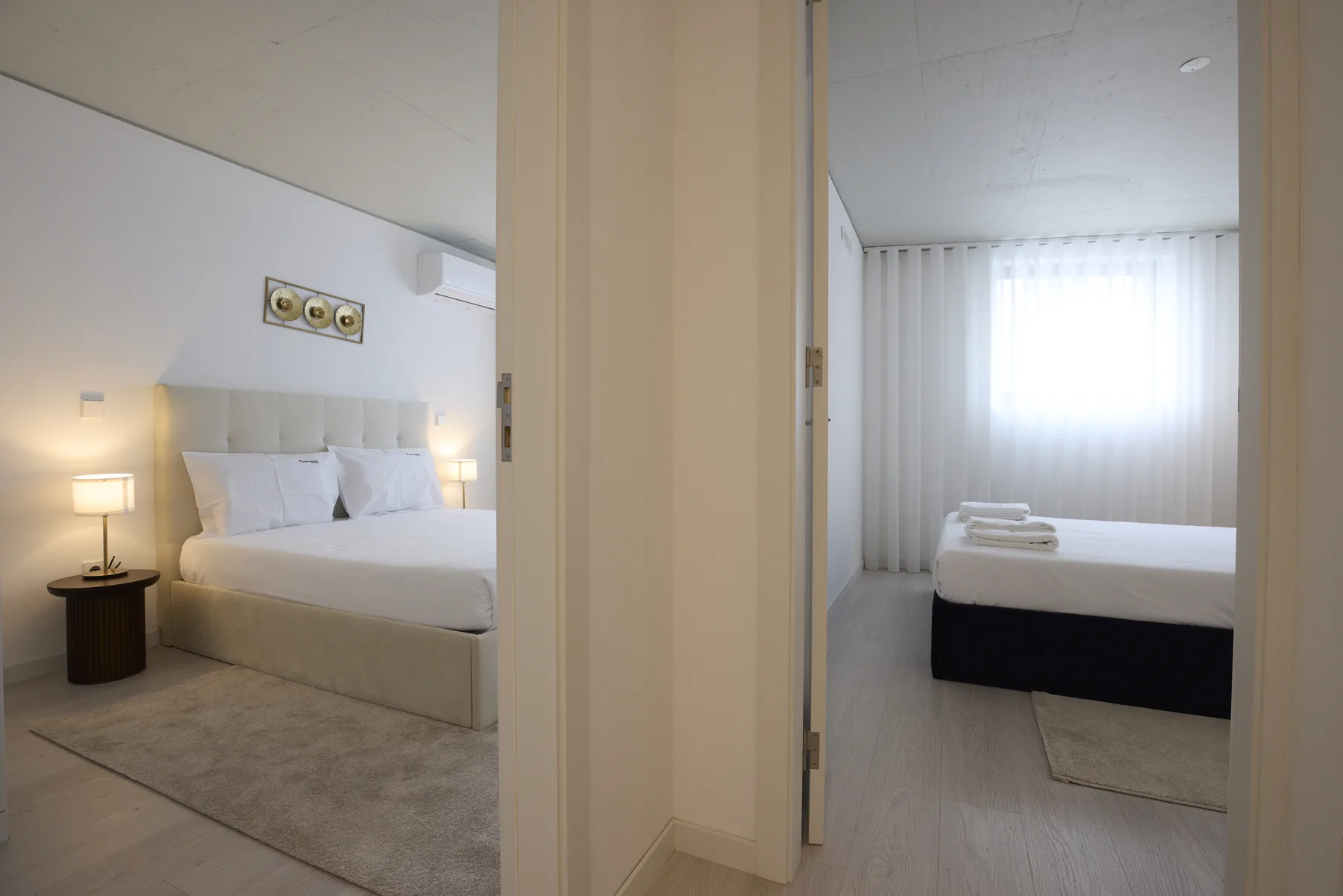 Two bedroom sleeping areas are visible through open doorways, with beds and a window.
