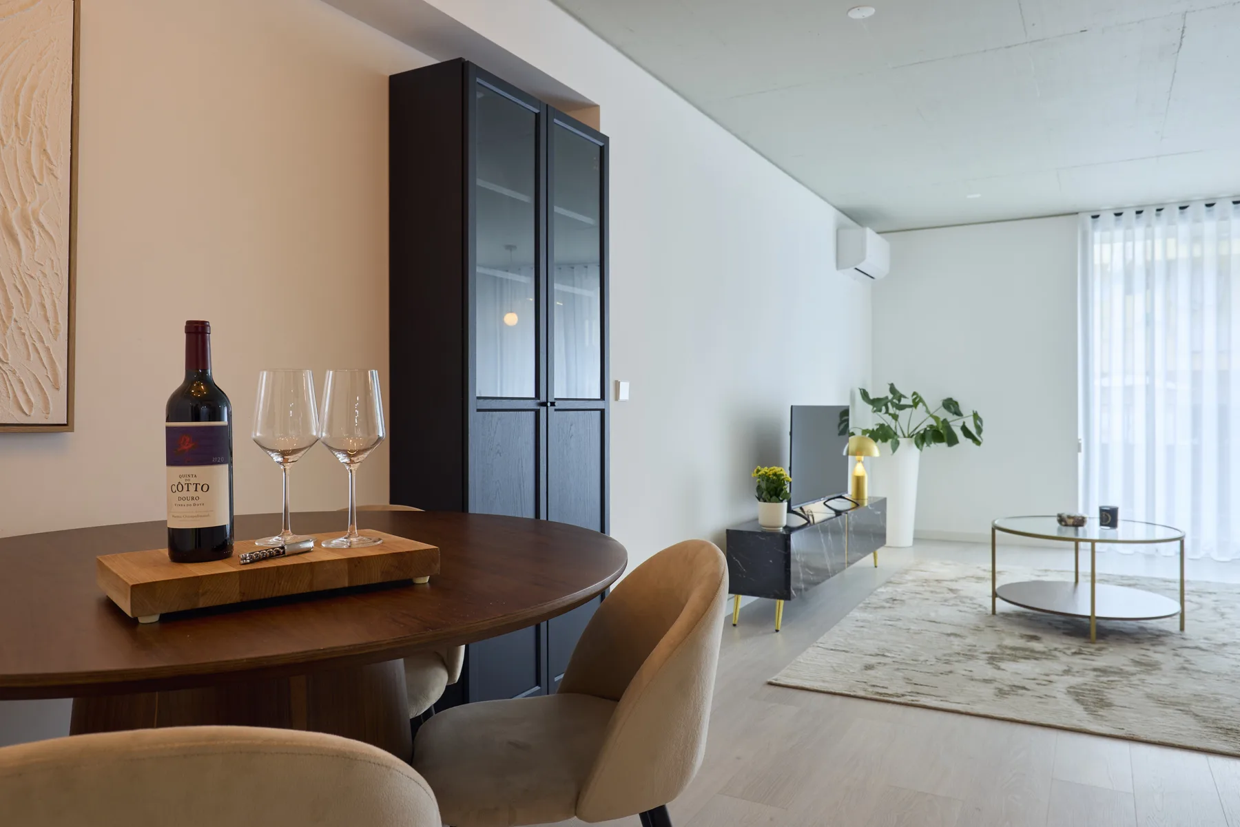 A modern living and dining area with a table, seating, and a rug.
