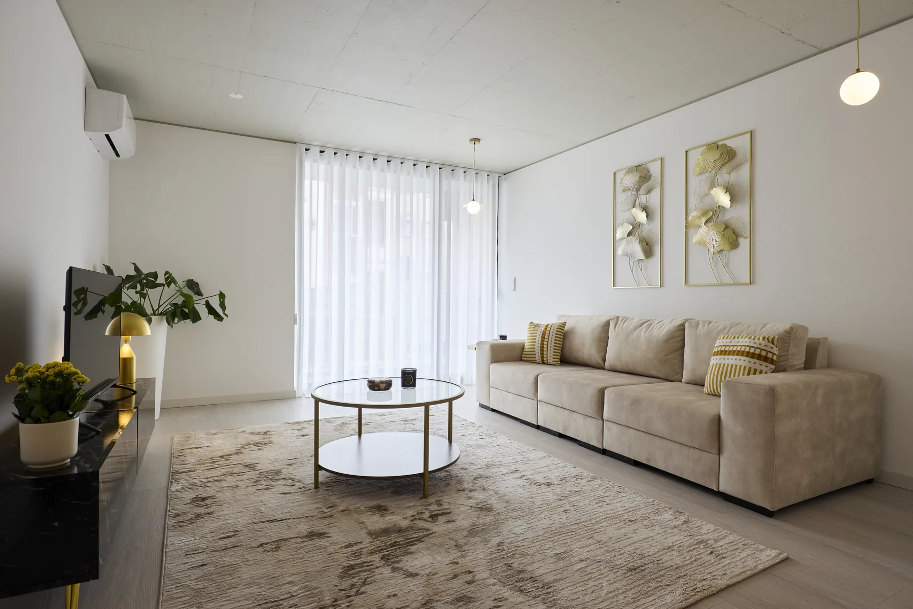 A bright living room with a sofa and round coffee table.