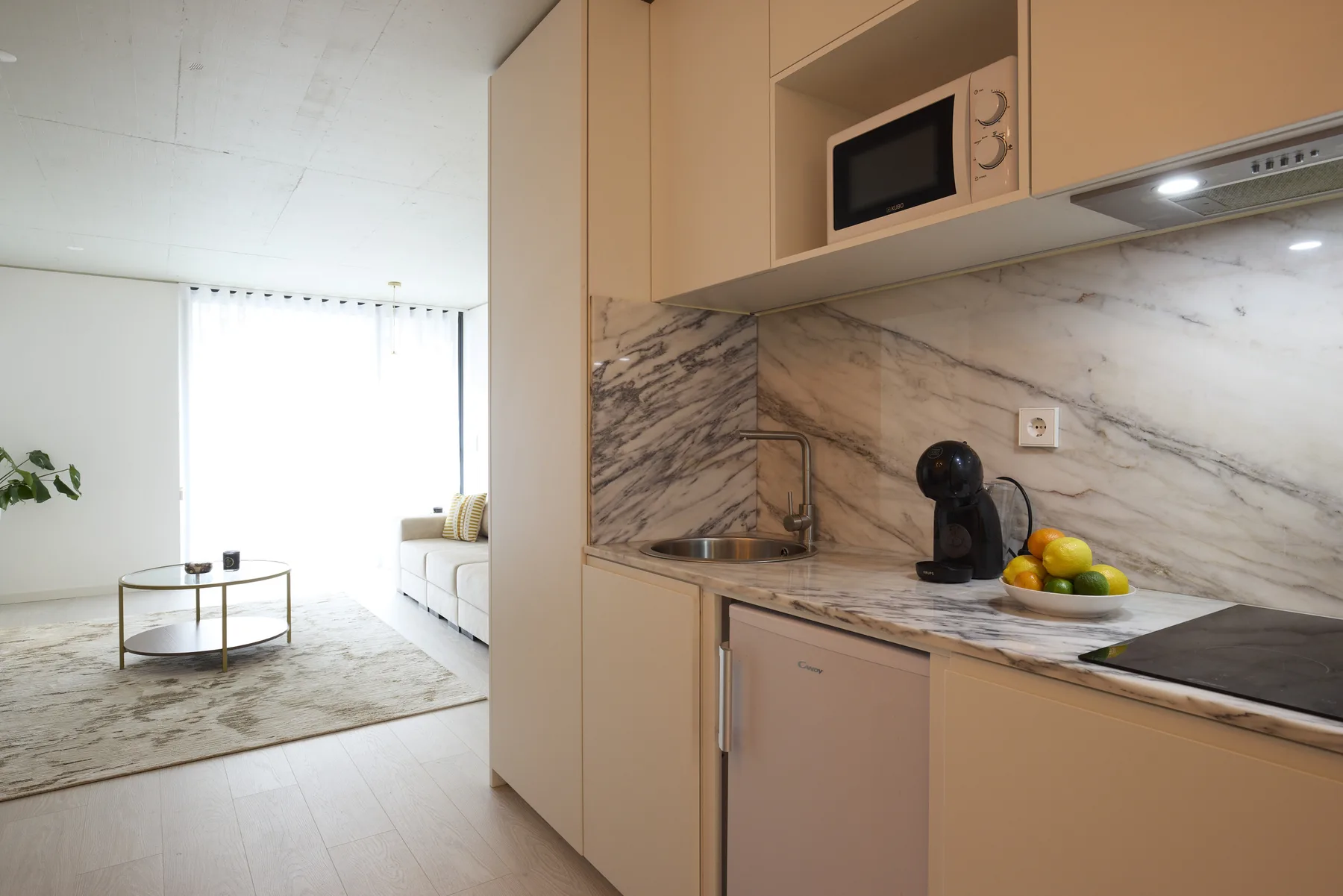 A compact kitchen with a counter opens onto a bright living area.