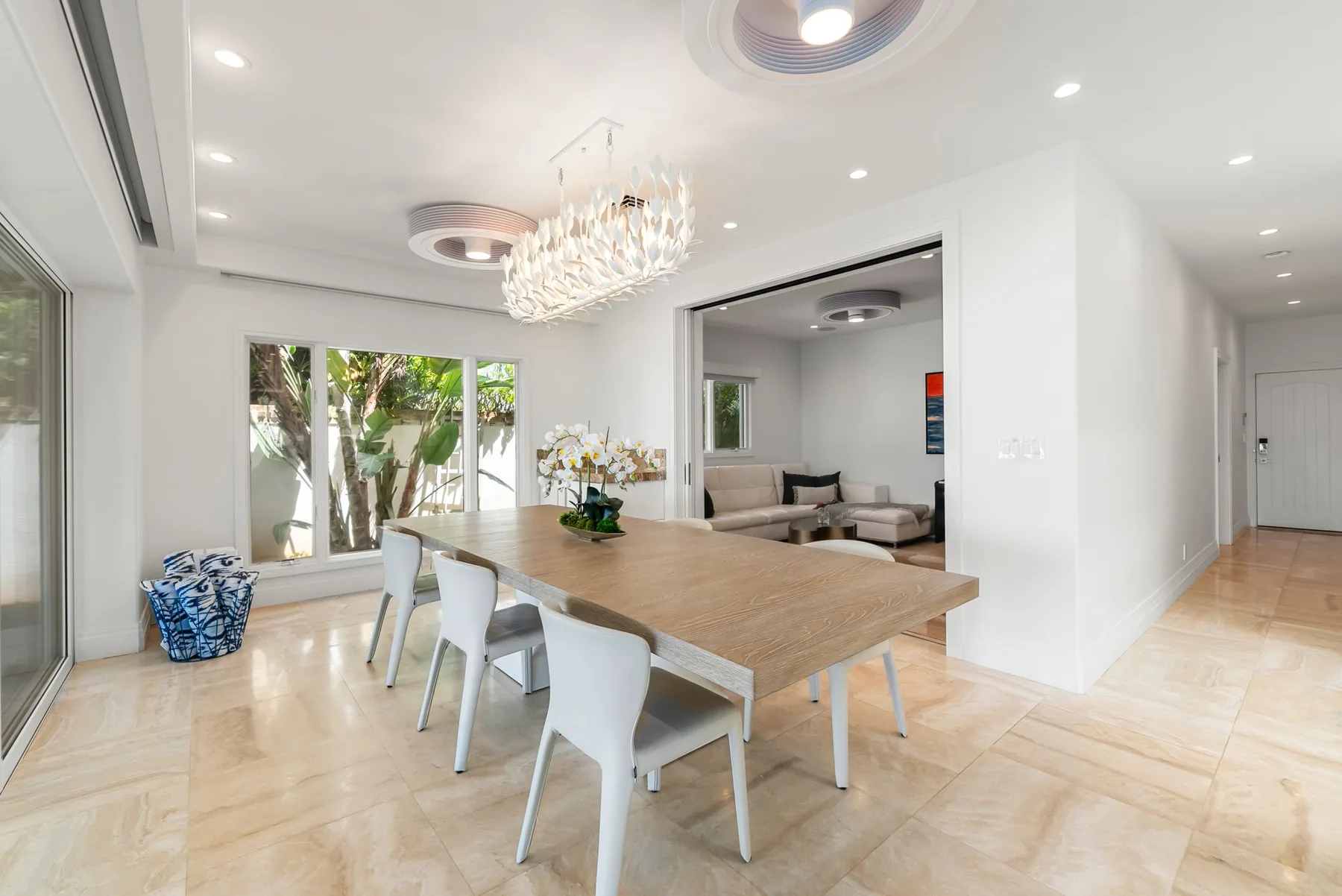 Un comedor luminoso con una mesa larga de madera y sillas junto a grandes ventanas.