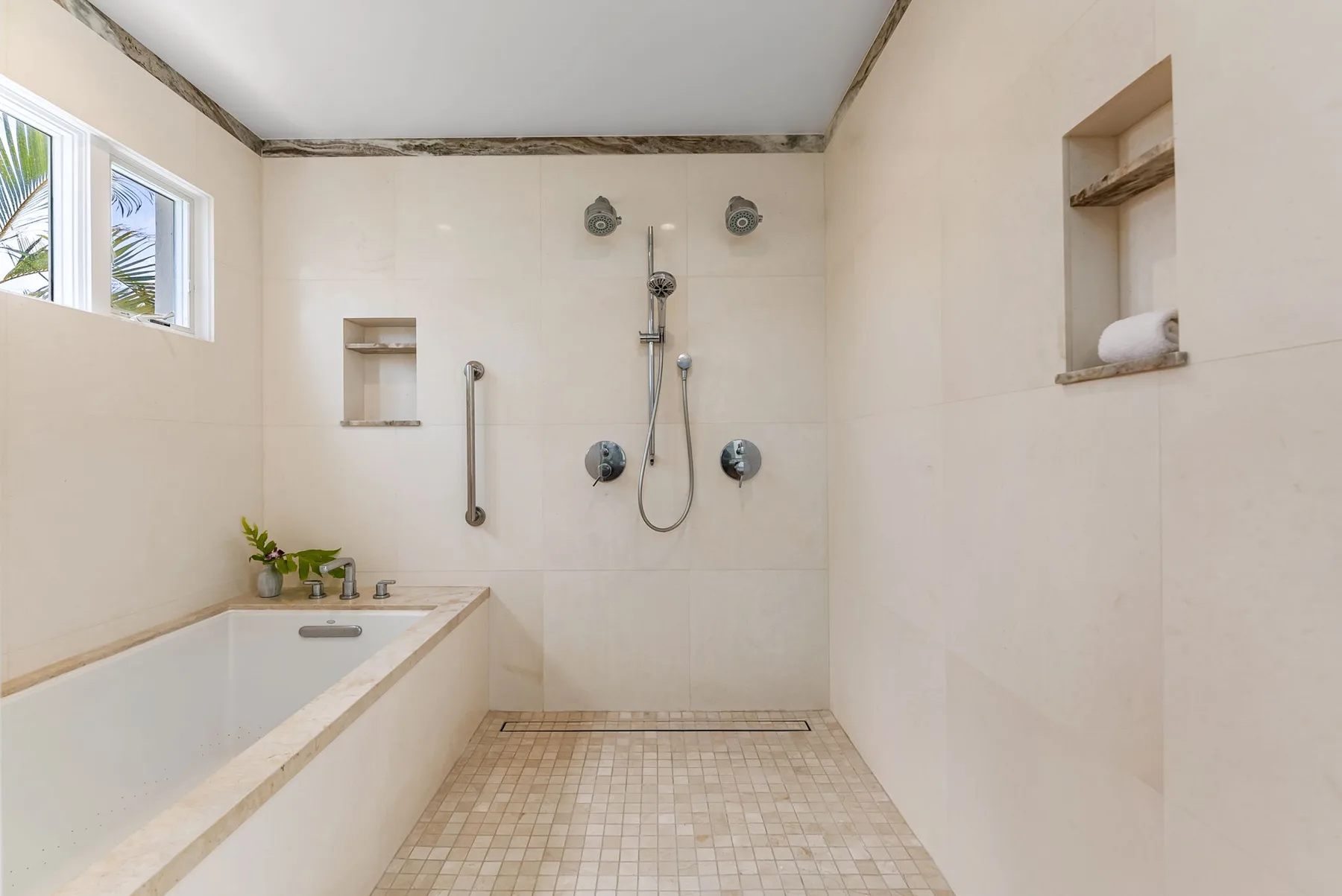 Un baño luminoso con bañera y ducha al fondo.