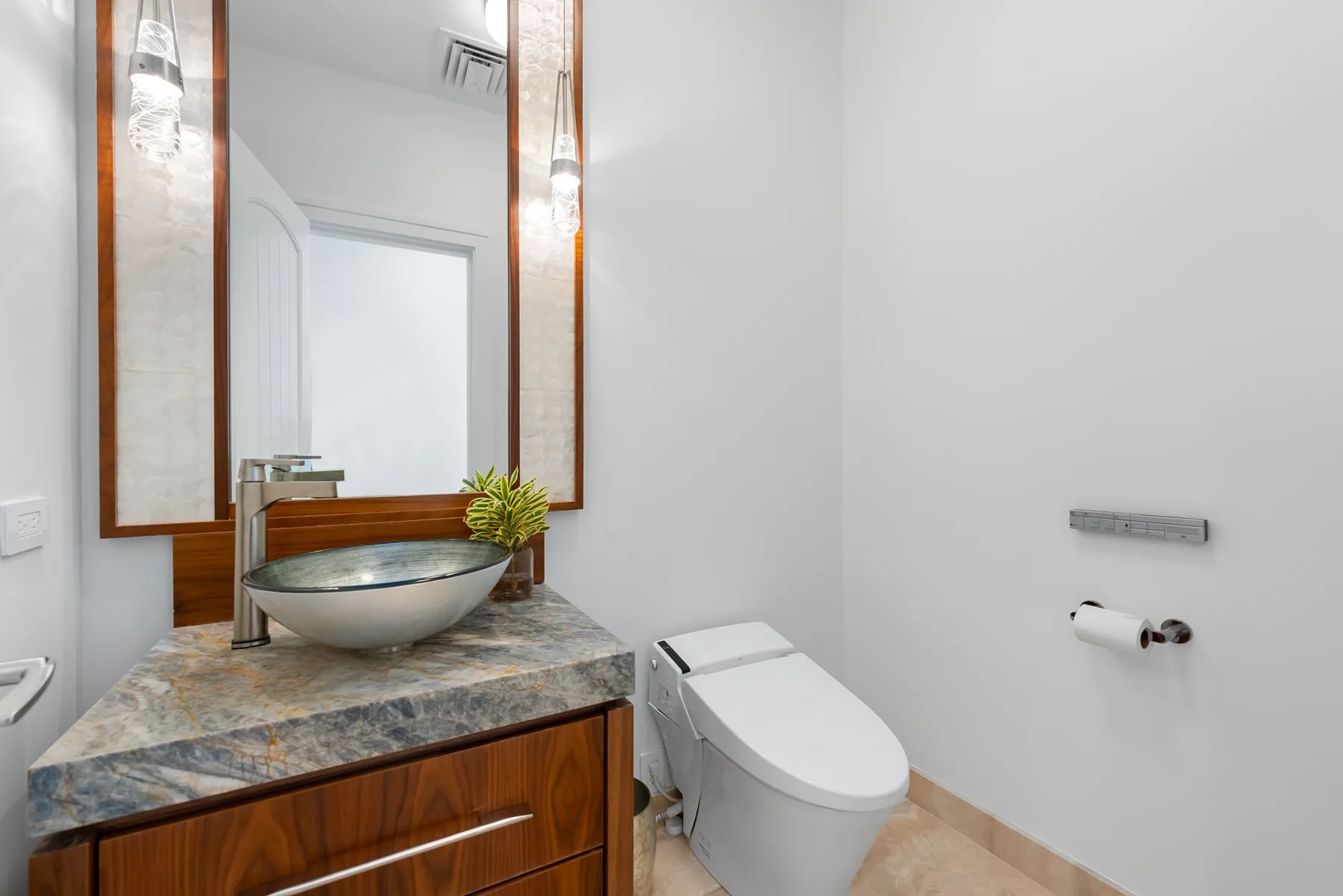 Un baño con lavabo sobre encimera, mueble y sanitario.