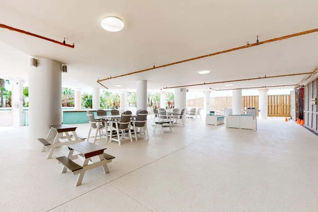 A bright open dining area with tables and seating beside large windows.
